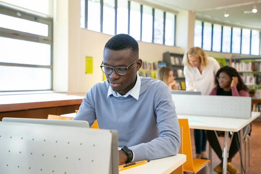 Un étudiant lit en bibliothèque