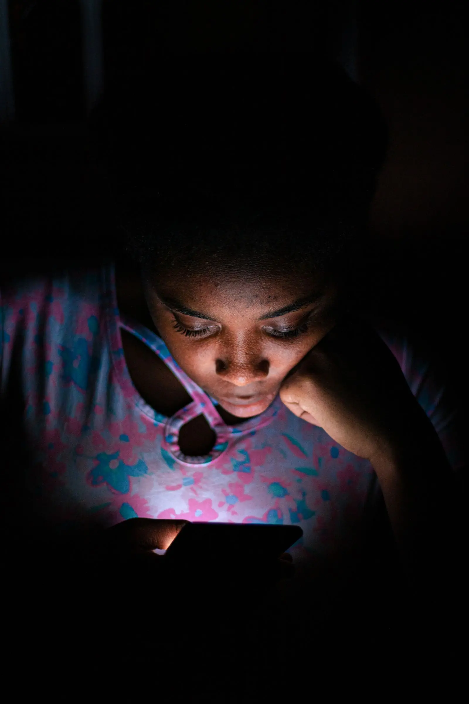 Une étudiante cherche des informations sur son téléphone, le soir