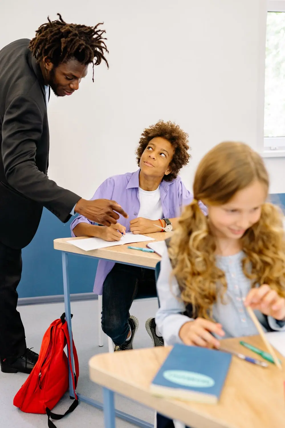 Une enseignante accompagne une élève pendant un exercice